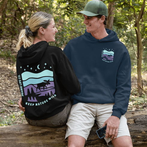 Featuring a bold moose silhouette set against a serene forest landscape, this design celebrates adventure, conservation, and life beyond the pavement.