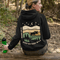 This premium hoodie features a moose silhouette wandering across prairie hills, Pine trees and a clear night sky filled with stars and a crescent moon.