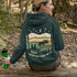 This premium hoodie features a moose silhouette wandering across prairie hills, Pine trees and a clear night sky filled with stars and a crescent moon.