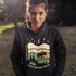 Featuring a bold moose silhouette layered over rolling hills, pine trees, and a starry night sky, this hoodie is a tribute to Canada’s wild landscapes.