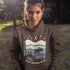 Featuring a moose design paired with a nature-inspired landscape, this hoodie reflects the beauty of Canada’s wild spaces and the importance of protecting them.