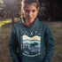 Featuring a moose design paired with a nature-inspired landscape, this hoodie reflects the beauty of Canada’s wild spaces and the importance of protecting them.