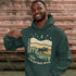 Featuring a bold moose silhouette layered over rolling hills, pine trees, and a starry night sky, this hoodie is a tribute to Canada’s wild landscapes.