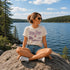 Woman sitting on a rock by a lake wearing a 'Lake Days' t-shirt.