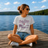 Woman sitting on a dock by a lake wearing a 'Lake Days' t-shirt.