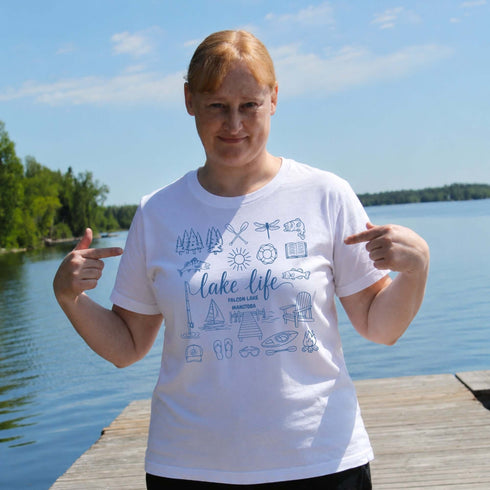 Person wearing a 'Lake Life' t-shirt by a lake