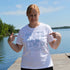 Person wearing a 'Lake Life' t-shirt by a lake