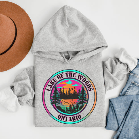 Featuring a stunning lake scene with a vibrant sunset, this hoodie captures the beauty of Lake of the Woods in Ontario, where tranquil waters meet the warm glow of a setting sun.