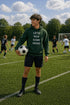 Person holding a soccer ball on a soccer field with a humorous hoodie