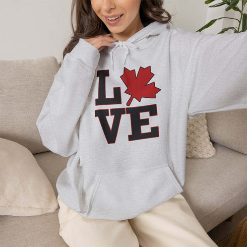 Love Canada hoodie featuring bold black lettering and red Canadian maple leaf graphic on a unisex sweatshirt