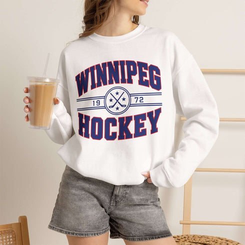 Winnipeg Hockey 1972 vintage-style unisex crewneck sweatshirt with collegiate lettering, crossed hockey sticks and retro hockey graphic by Prairie Life Co.
