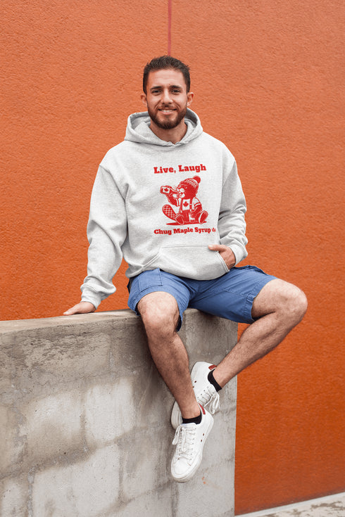 Our "Live, Laugh, Chug Maple Syrup" hoodie Features an iconic beaver rocking a Canada shirt and toque while chugging a bottle of maple syrup.