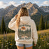 Vintage outdoor hoodie featuring a matching left chest graphic and a large back design inspired by hiking, forests, mountains, and adventure on a premium unisex hoodie displayed in an outdoor lifestyle setting.