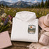 Vintage outdoor hoodie featuring a matching left chest graphic and a large back design inspired by hiking, forests, mountains, and adventure on a premium unisex hoodie displayed in an outdoor lifestyle setting.