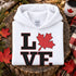 Love Canada hoodie featuring bold black lettering and red Canadian maple leaf graphic on a unisex sweatshirt