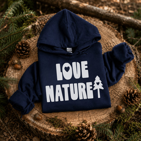 Navy blue hoodie with 'Love Nature' text on a wooden stump with pinecones and branches.
