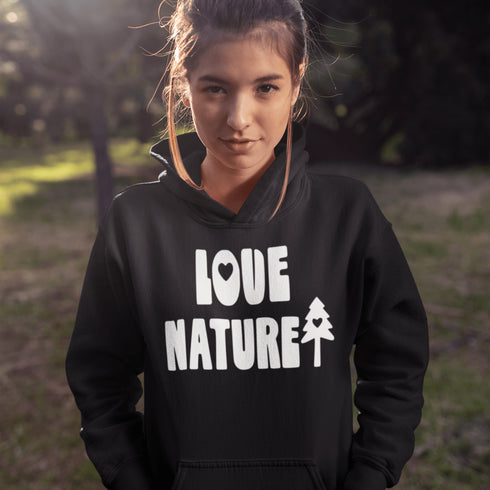 Woman wearing a black hoodie with 'Love Nature' text and a tree graphic outdoors.