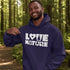 Man wearing a purple hoodie with 'Love Nature' text in a forest setting