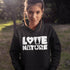 Person wearing a black hoodie with 'Love Nature' text in a natural setting