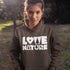 Woman wearing a hoodie with 'Love Nature' text in a natural setting