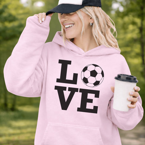 Hoodie with bold LOVE design featuring a soccer ball replacing the O, worn by woman holding coffee cup outdoors