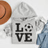 Hoodie with bold LOVE design featuring a soccer ball replacing the O, worn by woman holding coffee cup outdoors