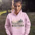 person wearing manitoba prairie life hoodie with farm and wheat field design standing in prairie field