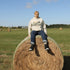 person wearing manitoba prairie life hoodie with farm and wheat field design standing in prairie field