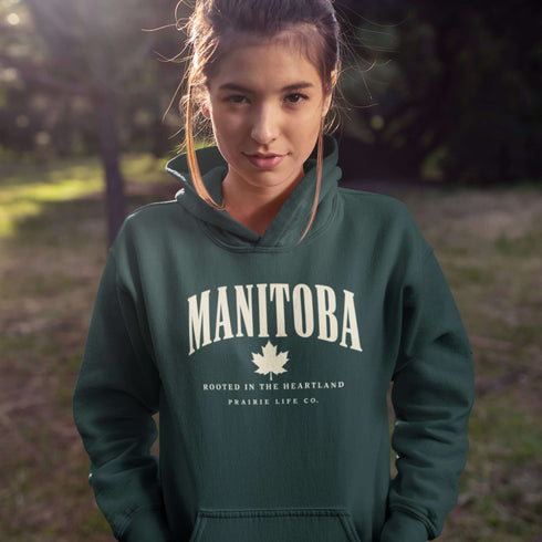 Manitoba Rooted in the Heartland hoodie with maple leaf and vintage collegiate lettering on a unisex Gildan sweatshirt