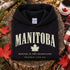 Manitoba Rooted in the Heartland hoodie with maple leaf and vintage collegiate lettering on a unisex Gildan sweatshirt