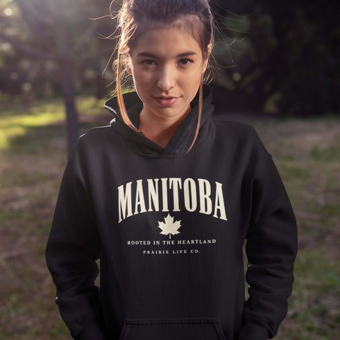 Manitoba Rooted in the Heartland hoodie with maple leaf and vintage collegiate lettering on a unisex Gildan sweatshirt