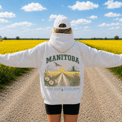 Vintage-inspired Manitoba prairie hoodie featuring a matching left chest design and oversized back graphic displayed on a unisex hoodie lifestyle mockup in an outdoor prairie setting. Available in multiple hoodie colors.