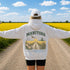 Vintage-inspired Manitoba prairie hoodie featuring a matching left chest design and oversized back graphic displayed on a unisex hoodie lifestyle mockup in an outdoor prairie setting. Available in multiple hoodie colors.
