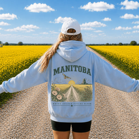 Vintage-inspired Manitoba prairie hoodie featuring a matching left chest design and oversized back graphic displayed on a unisex hoodie lifestyle mockup in an outdoor prairie setting. Available in multiple hoodie colors.