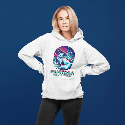Embrace the beauty of the North with our Manitoba - Wild & Free Hoodie, featuring a stunning graphic of an arctic fox beneath the shimmering northern lights.