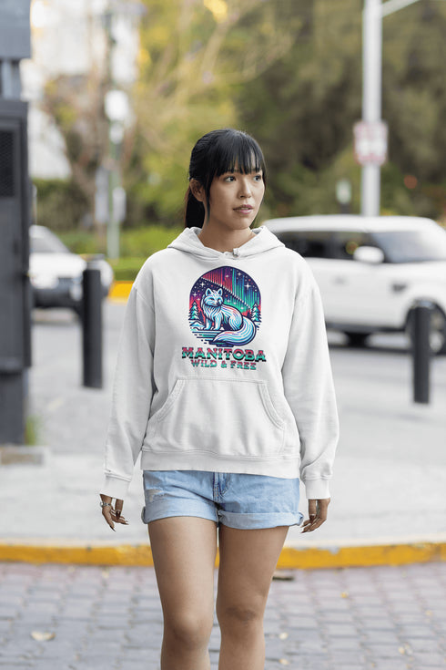 Embrace the beauty of the North with our Manitoba - Wild & Free Hoodie, featuring a stunning graphic of an arctic fox beneath the shimmering northern lights.