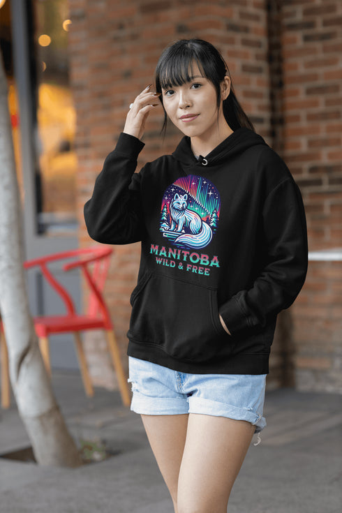 Embrace the beauty of the North with our Manitoba - Wild & Free Hoodie, featuring a stunning graphic of an arctic fox beneath the shimmering northern lights.