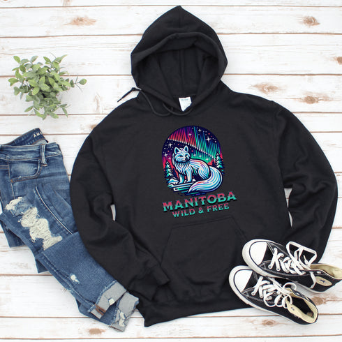 Embrace the beauty of the North with our Manitoba - Wild & Free Hoodie, featuring a stunning graphic of an arctic fox beneath the shimmering northern lights.