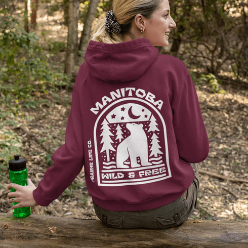 Featuring a bold bear graphic surrounded by pine trees and a crescent moon, this hoodie captures everything we love about Manitoba’s wild landscape.