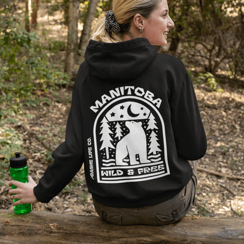 Featuring a bold bear graphic surrounded by pine trees and a crescent moon, this hoodie captures everything we love about Manitoba’s wild landscape.