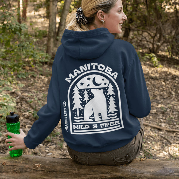 Featuring a bold bear graphic surrounded by pine trees and a crescent moon, this hoodie captures everything we love about Manitoba’s wild landscape.