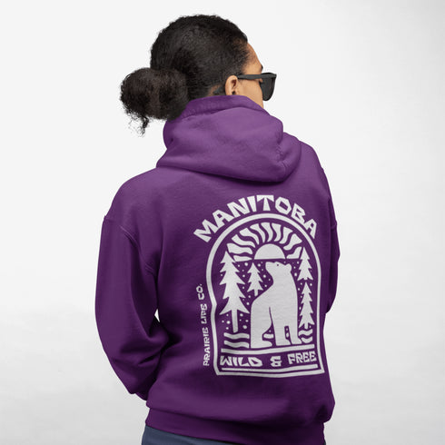 This cozy hoodie features a bold graphic of a bear surrounded by pine trees and rising sun—capturing the spirit of Manitoba’s rugged landscapes and Prairie Life culture.