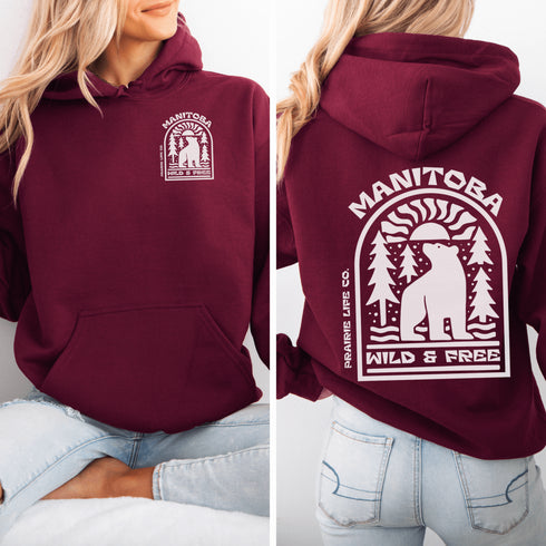 This cozy hoodie features a bold graphic of a bear surrounded by pine trees and rising sun—capturing the spirit of Manitoba’s rugged landscapes and Prairie Life culture.