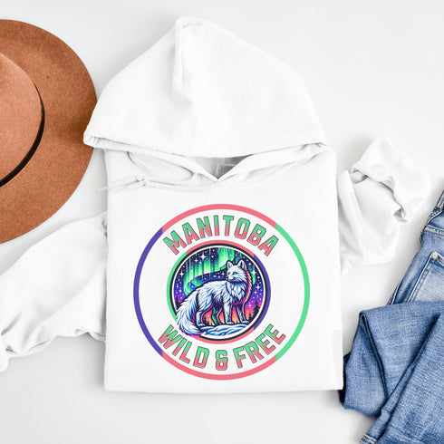 Unleash your wild side with our Manitoba – Wild & Free hoodie, featuring an enchanting graphic of an arctic fox beneath the dazzling northern lights.