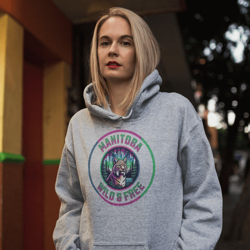 Step into the wild with our Manitoba – Wild & Free hoodie, featuring a striking graphic of a lynx under the glow of the northern lights.