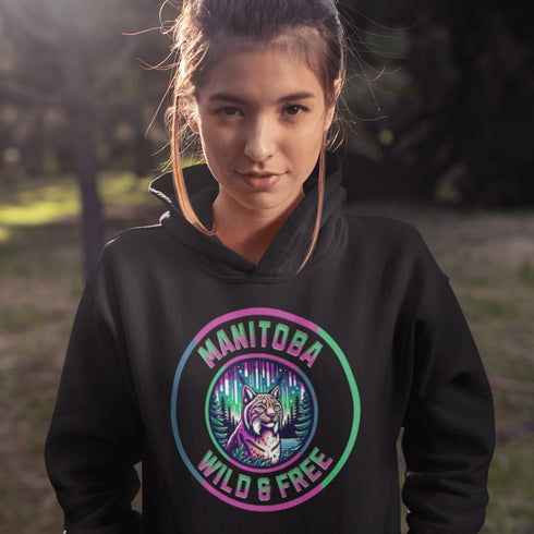 Step into the wild with our Manitoba – Wild & Free hoodie, featuring a striking graphic of a lynx under the glow of the northern lights.