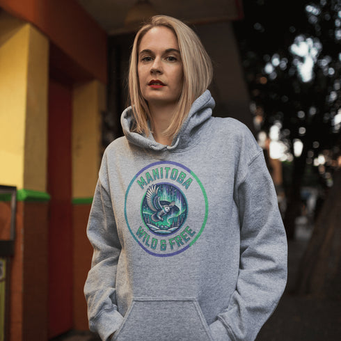 Embrace the magic of the prairies with our Manitoba – Wild & Free hoodie, featuring a captivating graphic of a snowy owl in flight beneath the shimmering northern lights.