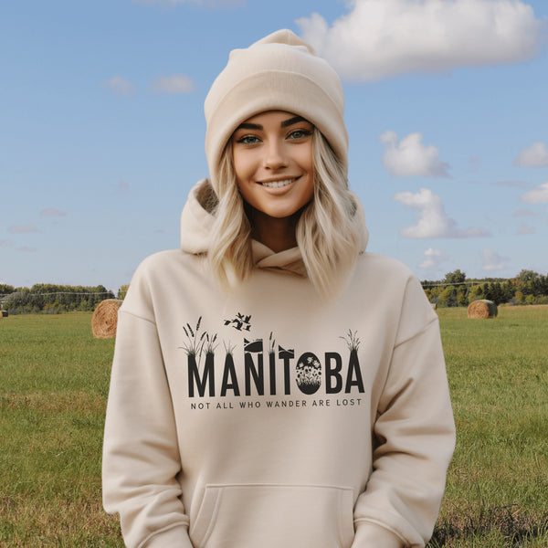 Featuring a serene prairie landscape, the design captures the essence of the heartland with wildflowers and prairie grasses growing out of the letters Manitoba.