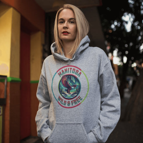 Soar high in our Manitoba – Wild & Free hoodie, featuring a bold flying bald eagle beneath the captivating northern lights.