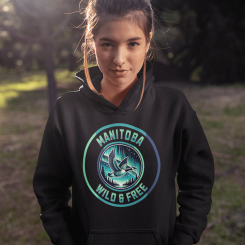 Embrace the spirit of the prairies with our Manitoba – Wild & Free hoodie, featuring a stunning graphic of a Canadian goose in flight beneath the mesmerizing northern lights.